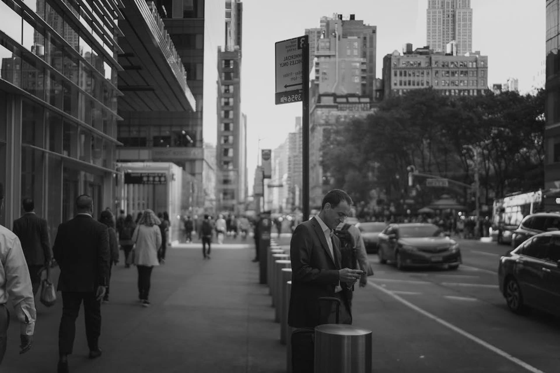 blurred man in sunglasses walking on a street with briefcase.